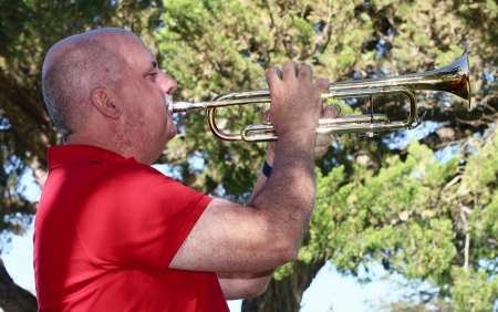 Rob Bentley, a music teacher from Liberty Middle School, plays taps.